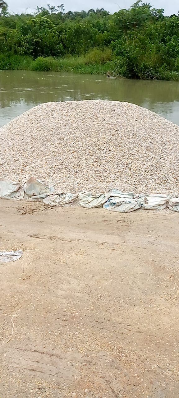 Construction aggregate stockpile beside the extraction waterway in Abudu