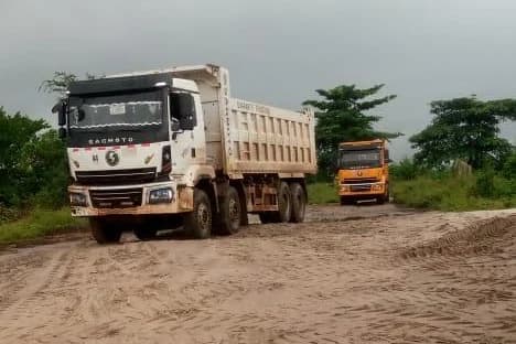 Loaded haul trucks moving along a sand route between the source and the delivery site